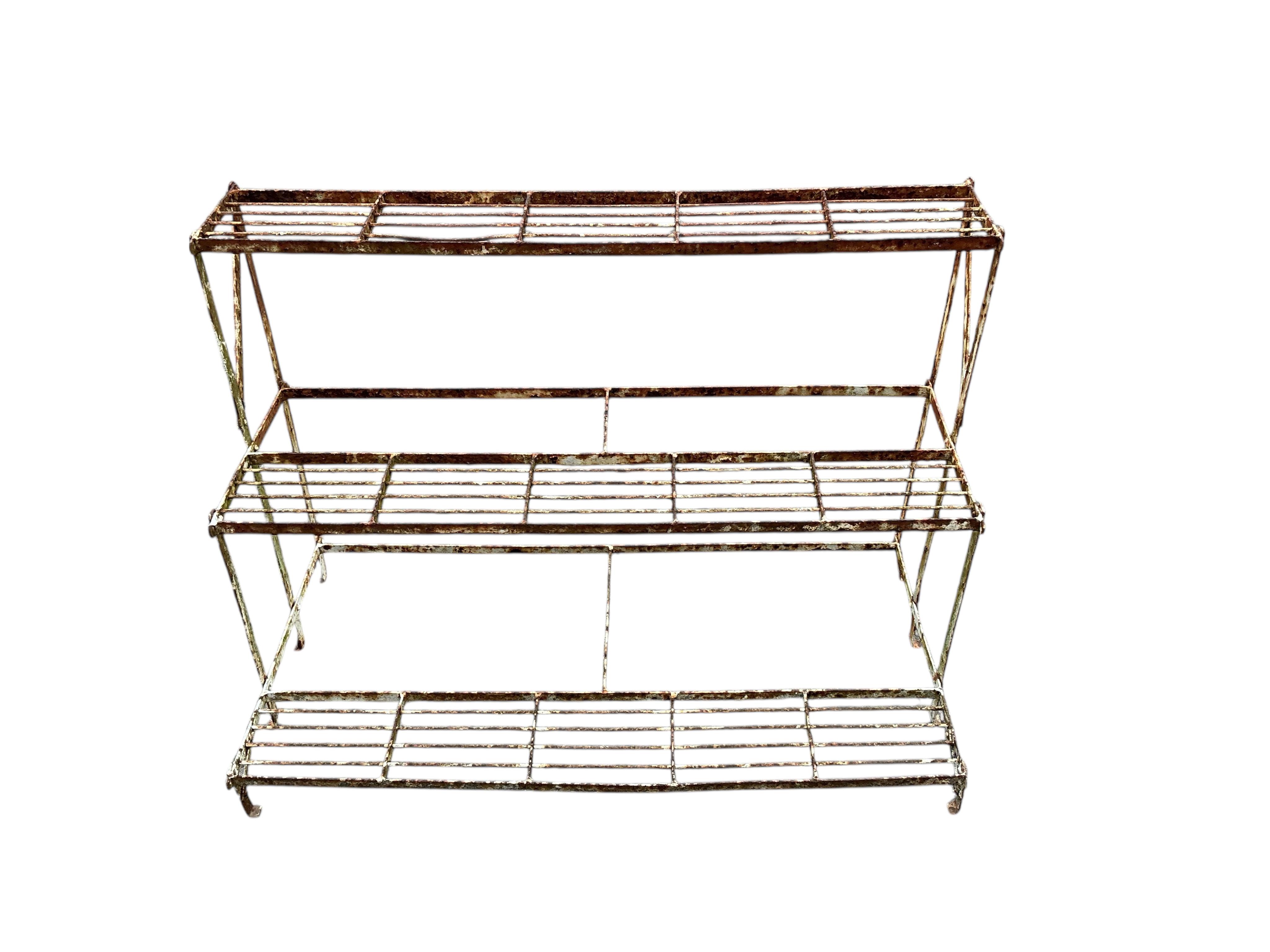 A painted wrought iron three tier pot stand, width 100cm, depth 50cm, height 73cm